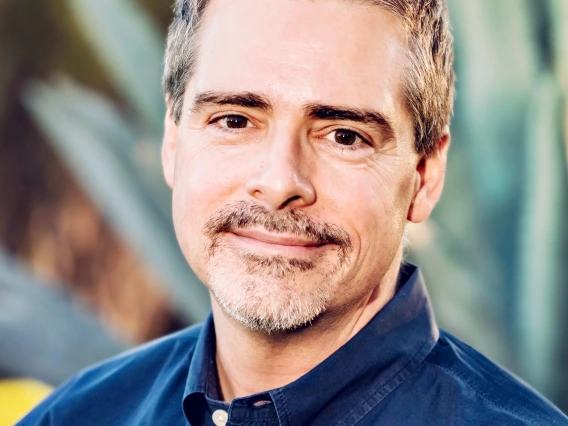 Professional Photo of Dr. Kory Floyd wearing a blue collared shirt against a background of an agave plant